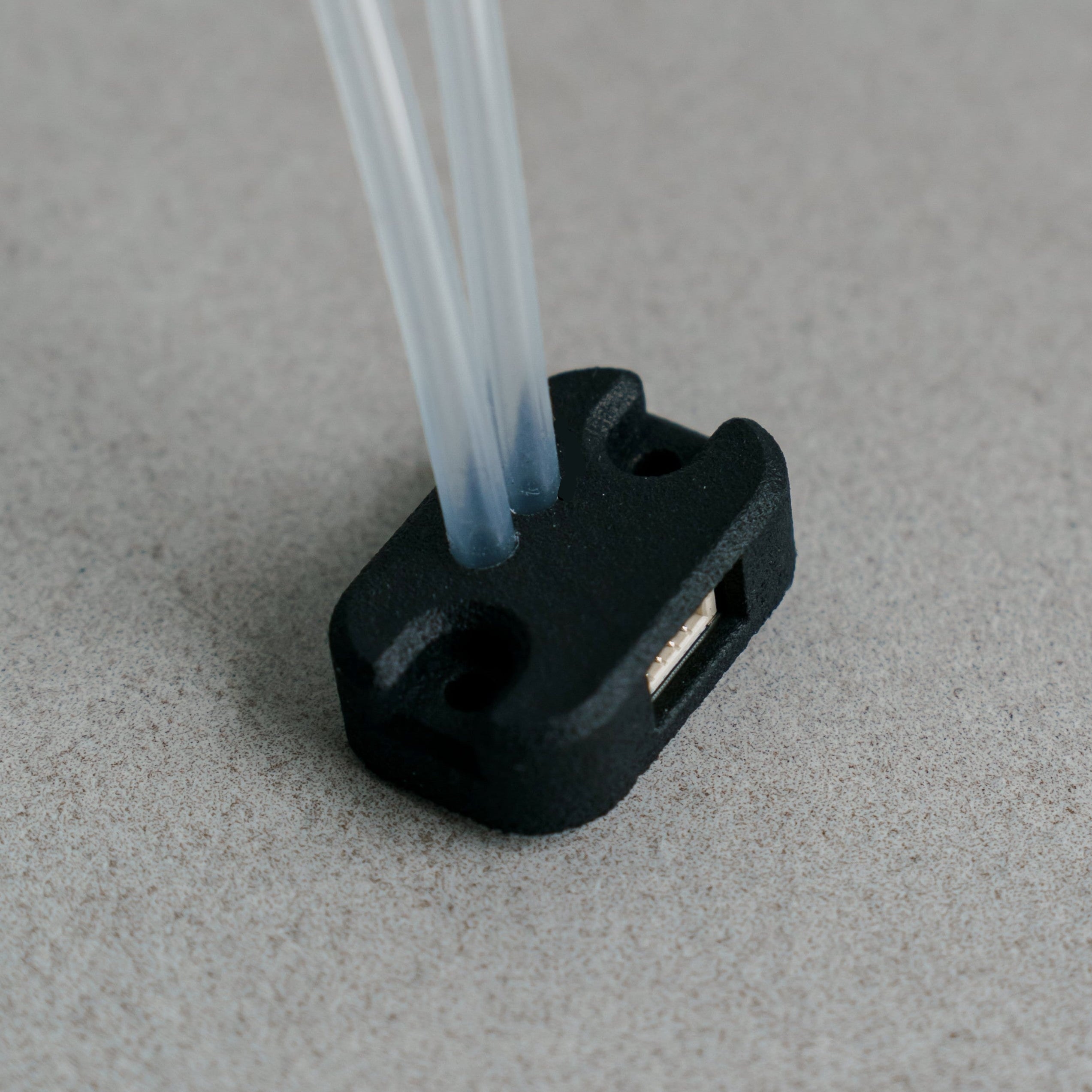 Siderion SDP33 Airspeed differential pressure sensor on a gray background. Silicone tubes are pointing up.