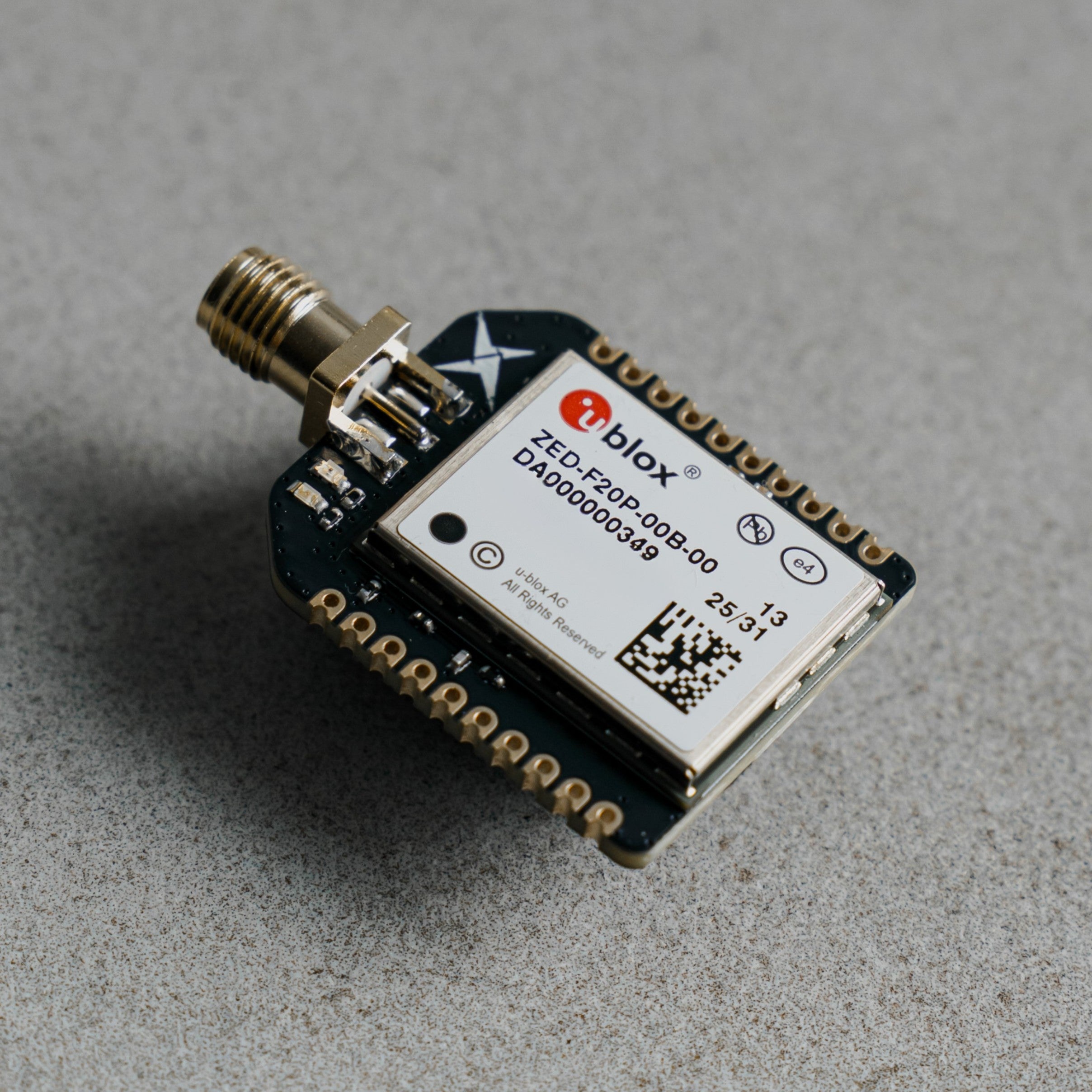 Siderion SP0700 ZED-F20P RTK GNSS device with SMA connector, on a gray background.