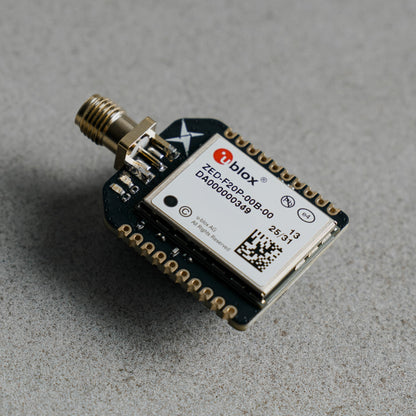 Siderion SP0700 ZED-F20P RTK GNSS device with SMA connector, on a gray background. 