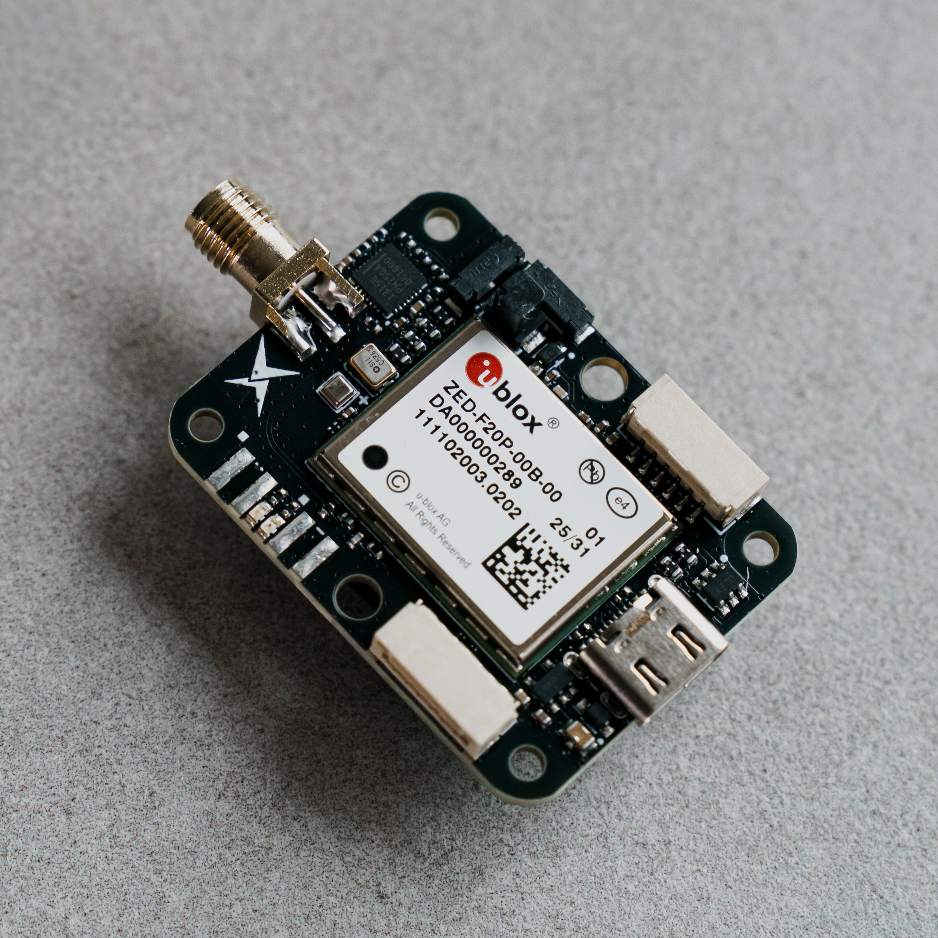 Siderion SP0703 ZED-F20P RTK GNSS module on a gray background. Top view.